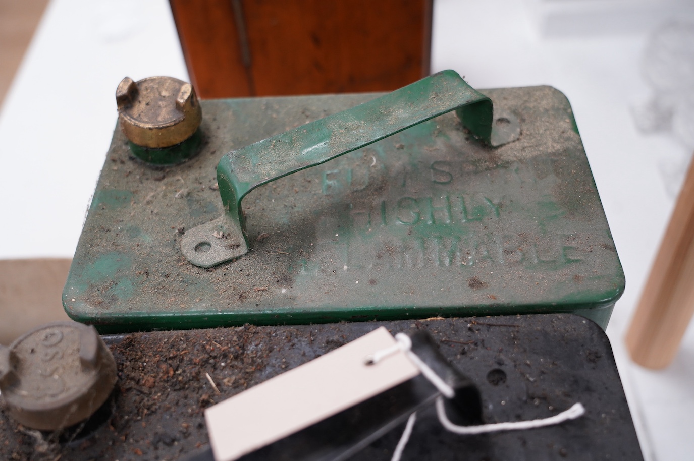 Three early Smiths car timepieces, two oil pressure gauges, a small brass headlamp and two petrol cans with brass caps, one embossed ‘Esso’ with corresponding casting on cap, the other unmarked. Condition - poor to fair